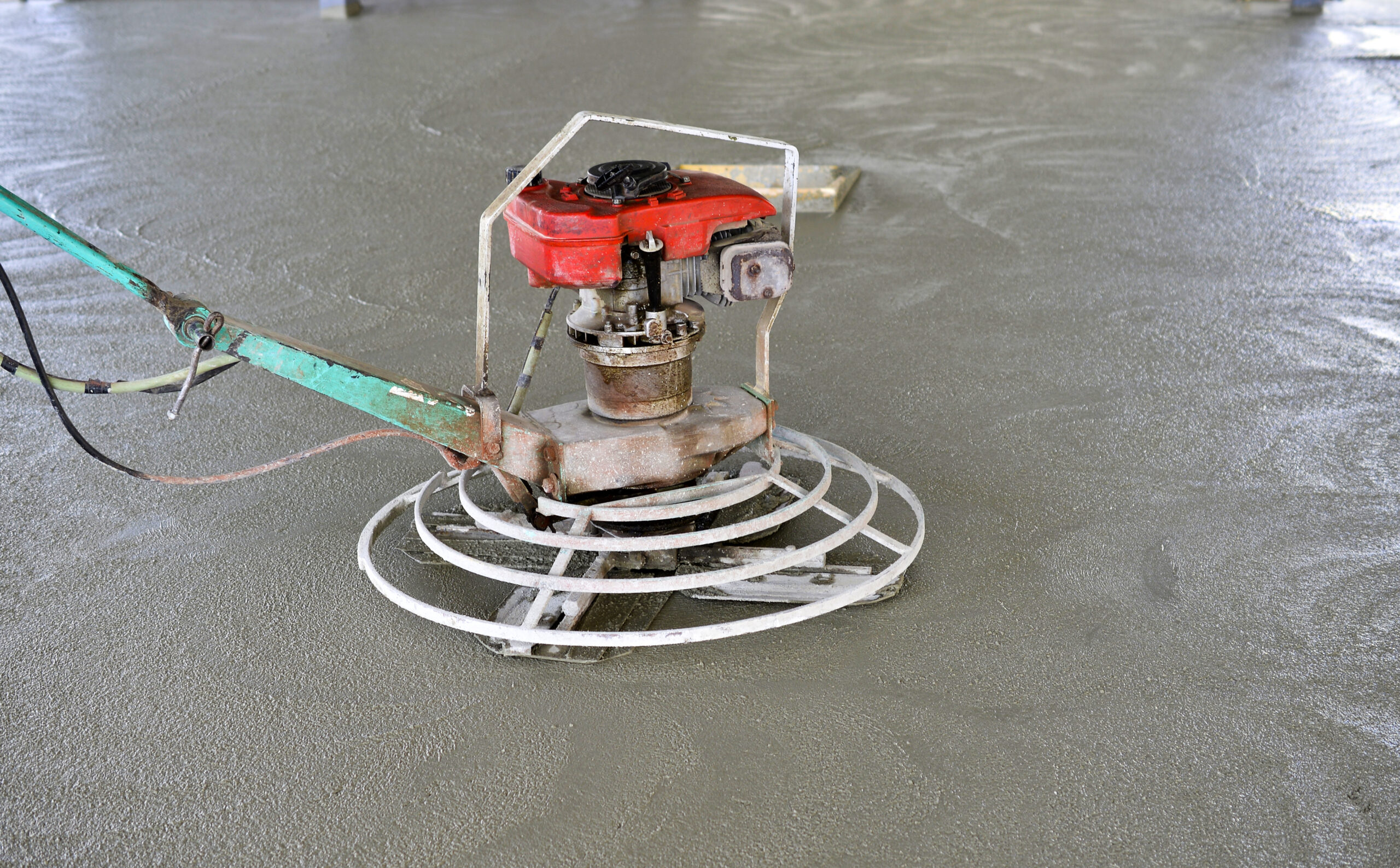 Construction worker pouring and finishing concrete
